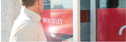 Personne ouvrant la porte d'une succursale Wolseley.