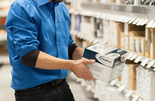 Homme en chemise bleue avec une boîte ProFlo.